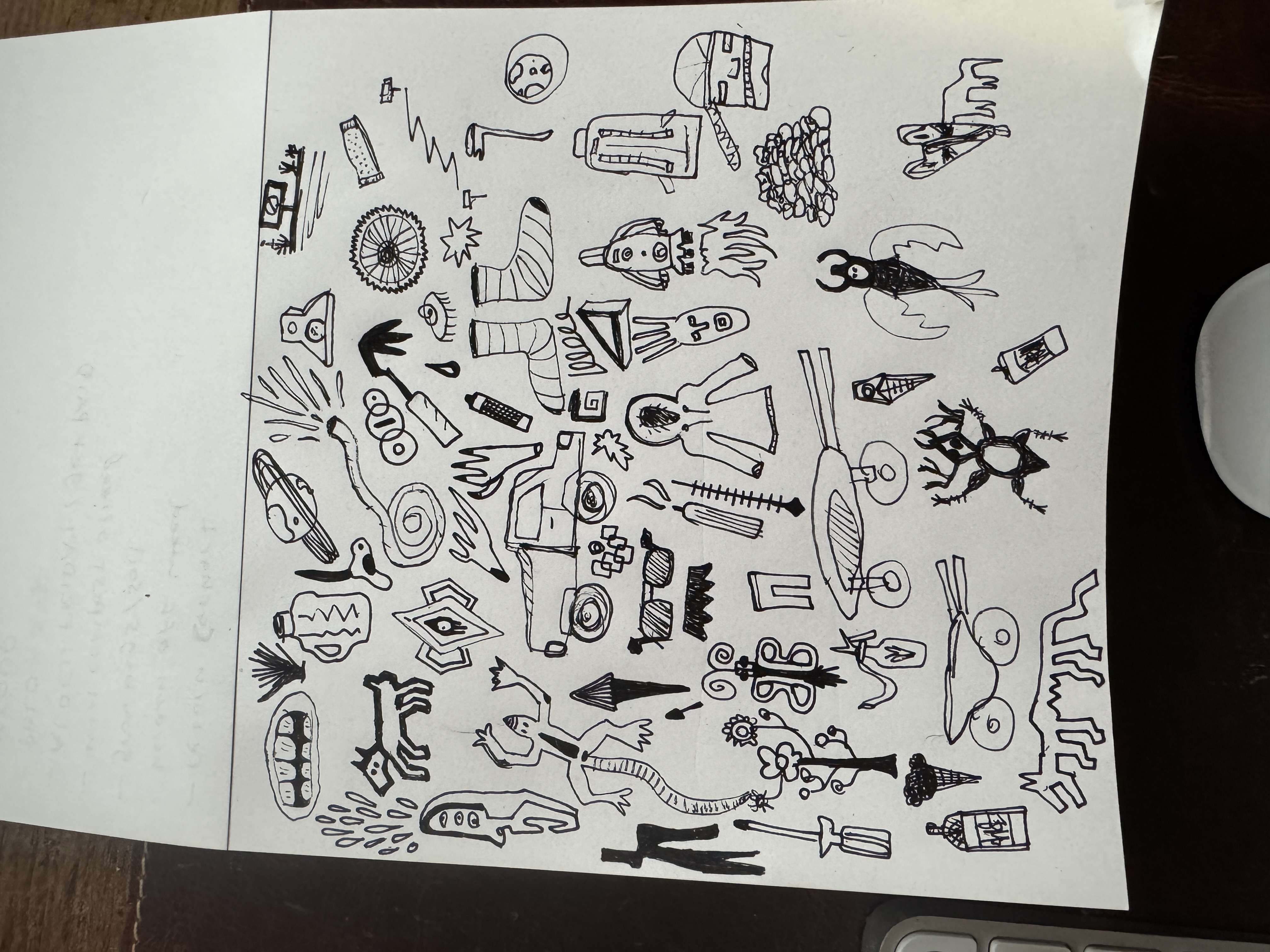 Sketchbook page of hand-drawn icons — ink on paper, dark desk